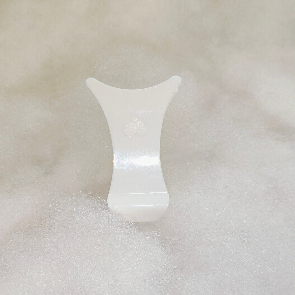 White ceramic vase on a textured beige surface